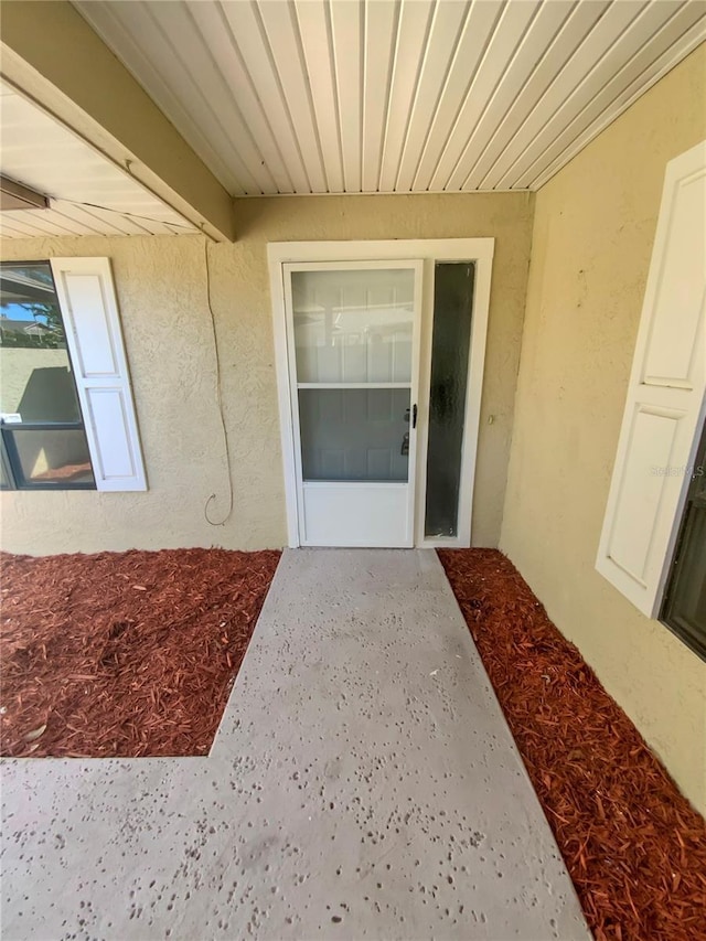 property entrance with stucco siding