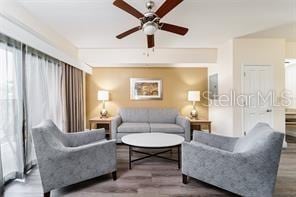 living room featuring a ceiling fan and wood finished floors