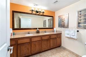 full bathroom with double vanity and a sink