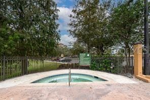 view of swimming pool with fence and a community hot tub