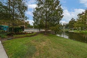 view of yard featuring a water view and fence