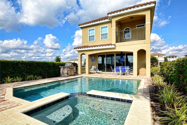 back of house with stucco siding, a patio area, fence, a balcony, and a tiled roof