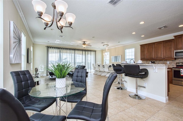 dining space with a healthy amount of sunlight, visible vents, and crown molding