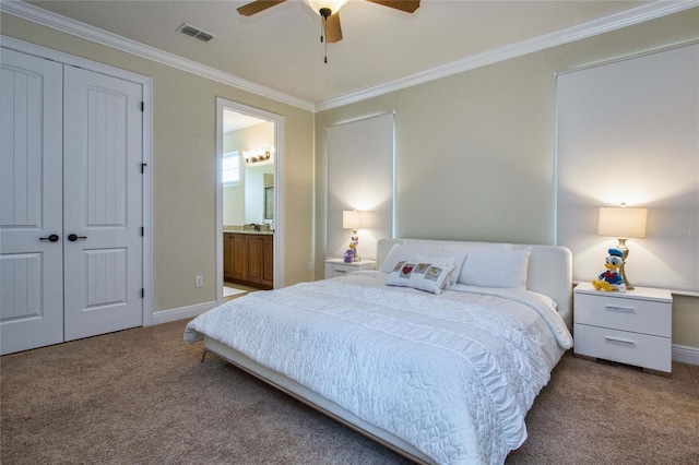 carpeted bedroom featuring ensuite bathroom, visible vents, baseboards, ornamental molding, and a closet