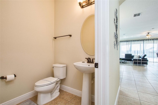 bathroom with visible vents, toilet, a sink, tile patterned flooring, and baseboards