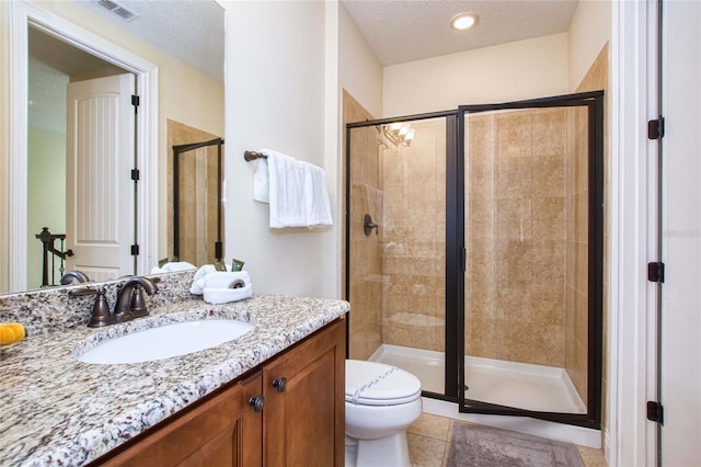 bathroom with toilet, a stall shower, visible vents, and a textured ceiling