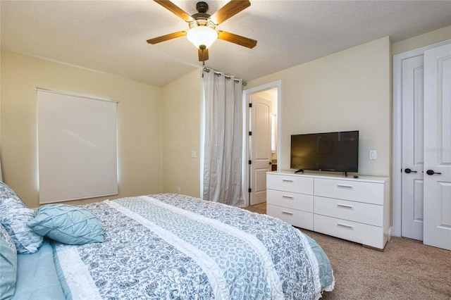 bedroom with light carpet, a textured ceiling, and a ceiling fan