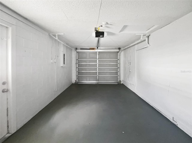 garage with a garage door opener and concrete block wall