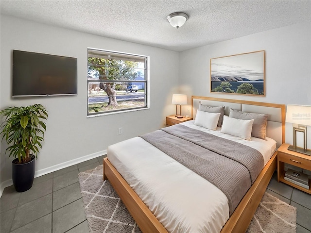 bedroom with a textured ceiling, baseboards, and tile patterned floors