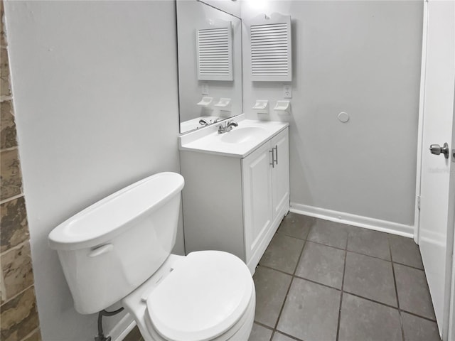 bathroom with vanity, tile patterned flooring, toilet, and baseboards