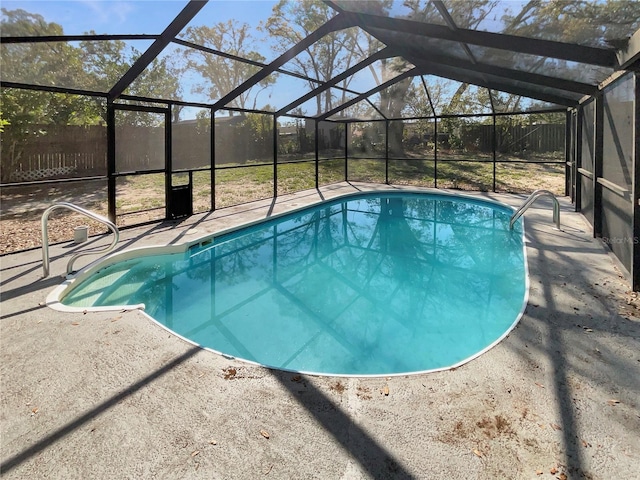 pool with a patio, fence, and glass enclosure