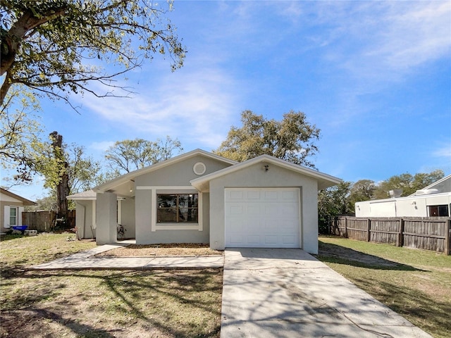 view of front of house with stucco siding, an attached garage, a front yard, fence, and driveway