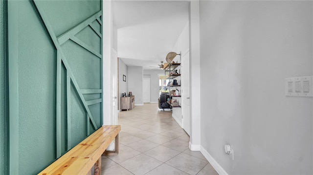 hall with light tile patterned flooring and baseboards