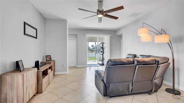 living area featuring light tile patterned floors, baseboards, visible vents, and a ceiling fan