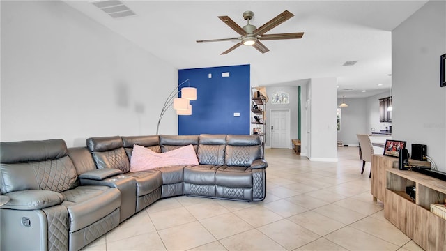 living area featuring ceiling fan, light tile patterned flooring, visible vents, and baseboards