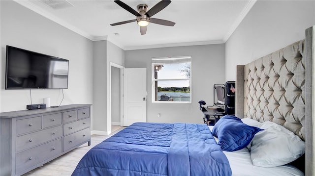 bedroom featuring light wood-type flooring, baseboards, visible vents, and ornamental molding