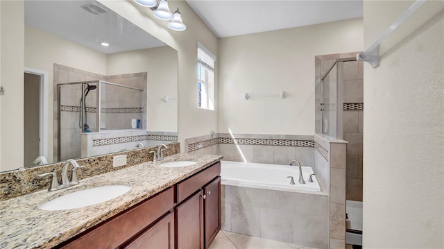 full bathroom featuring a stall shower, tile patterned flooring, a garden tub, and a sink