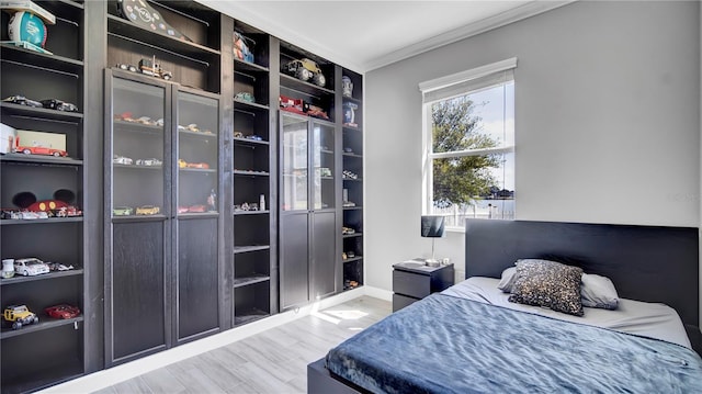 bedroom with crown molding and wood finished floors