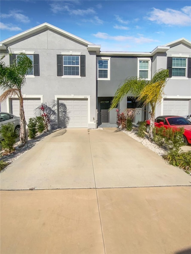 view of front facade with driveway, an attached garage, and stucco siding