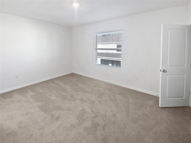 carpeted spare room with baseboards