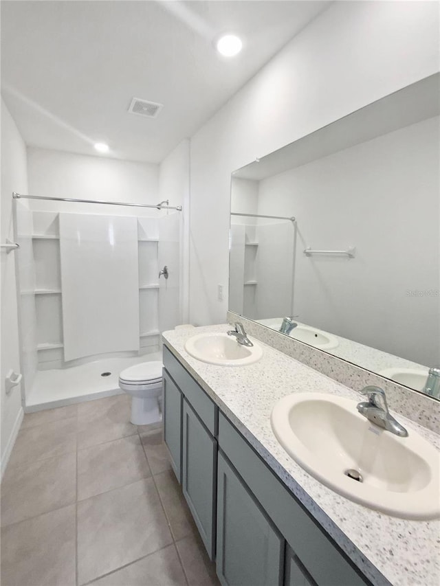 full bath featuring tile patterned floors, a sink, toilet, and a shower stall