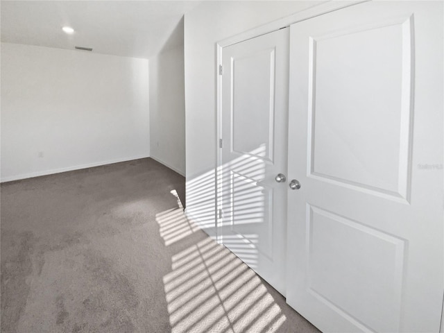 interior space featuring carpet floors, visible vents, and baseboards