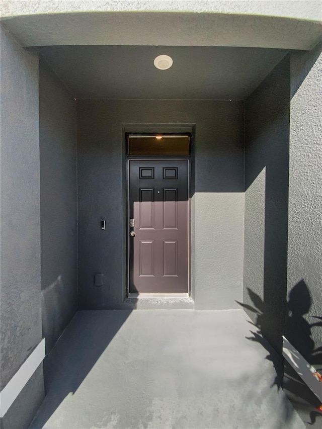 view of exterior entry featuring stucco siding