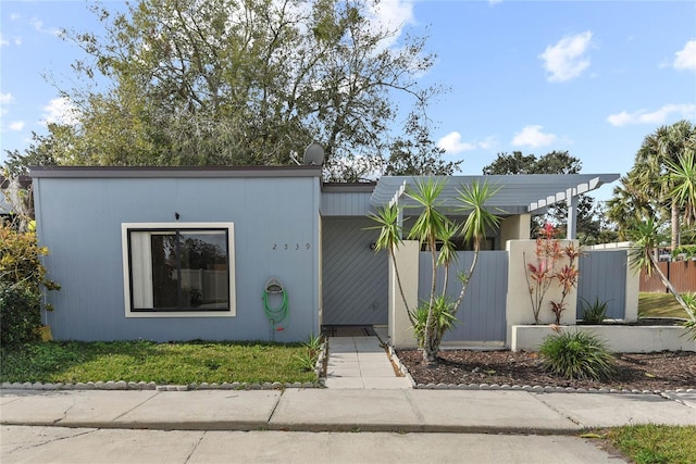 mid-century modern home with fence and a pergola