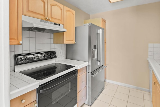 kitchen featuring electric stove, light brown cabinetry, tile counters, and under cabinet range hood