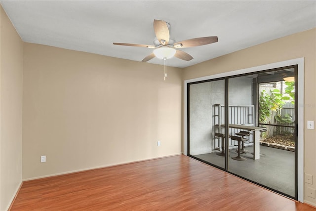 unfurnished room with ceiling fan, baseboards, and wood finished floors