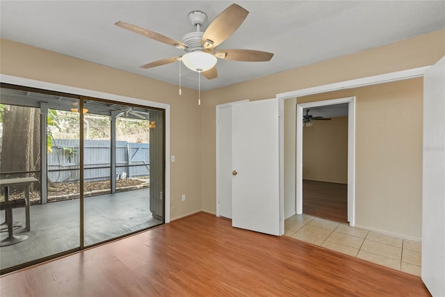 empty room featuring a ceiling fan, baseboards, and wood finished floors