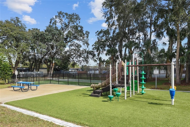 community jungle gym featuring a patio area, fence, and a yard