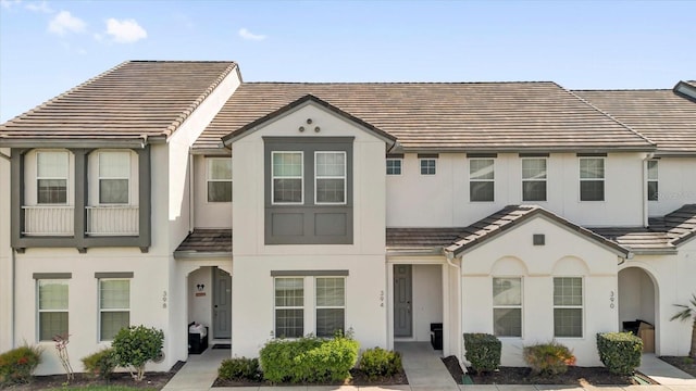 multi unit property featuring stucco siding and a tiled roof