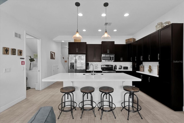 kitchen featuring tasteful backsplash, visible vents, stainless steel appliances, and a sink