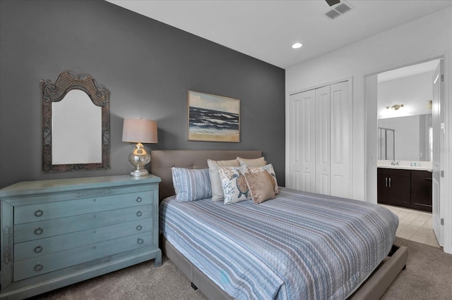 bedroom featuring visible vents, light colored carpet, and a closet