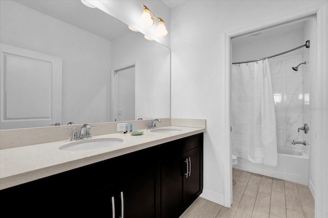 full bath featuring double vanity, toilet, shower / bath combo with shower curtain, and a sink