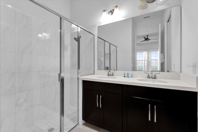 bathroom with a shower stall, double vanity, visible vents, and a sink