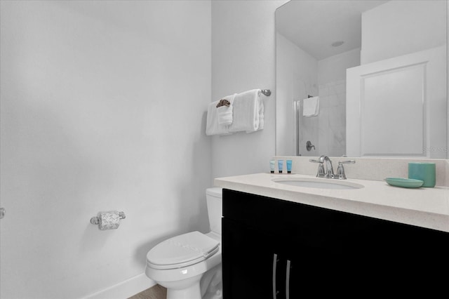 full bath featuring vanity, toilet, a shower, and baseboards