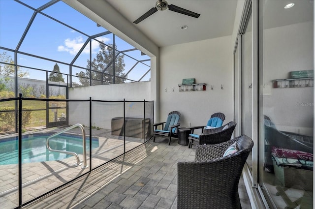 view of swimming pool with glass enclosure, a patio, and a ceiling fan