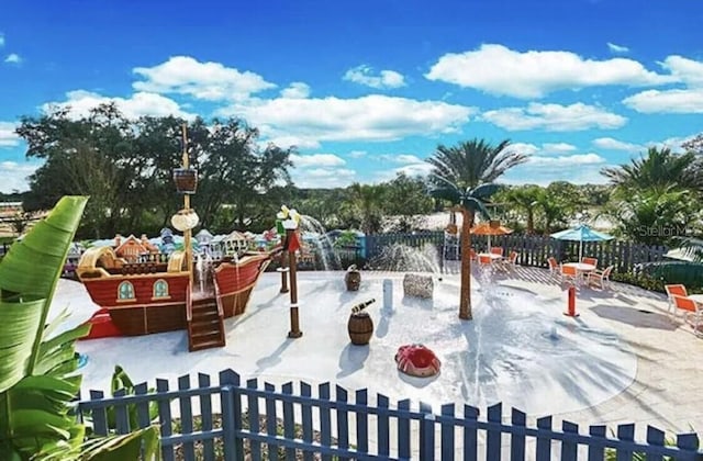 view of playground featuring a patio and fence