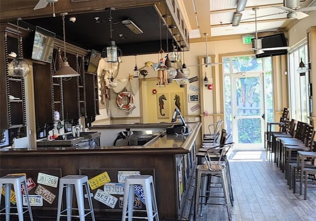 bar with wood finished floors and a ceiling fan