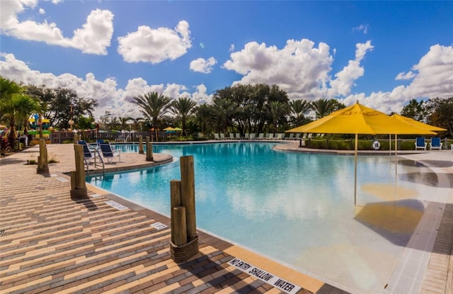 community pool featuring a patio and fence