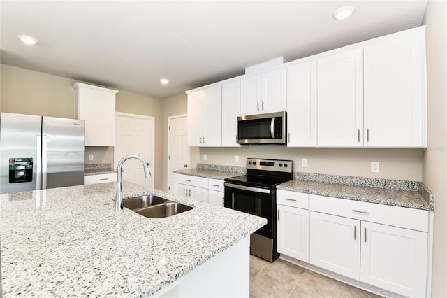 kitchen featuring recessed lighting, stainless steel appliances, a sink, white cabinetry, and an island with sink