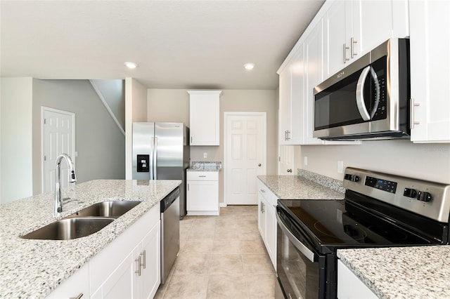 kitchen featuring recessed lighting, a sink, white cabinetry, appliances with stainless steel finishes, and light stone countertops