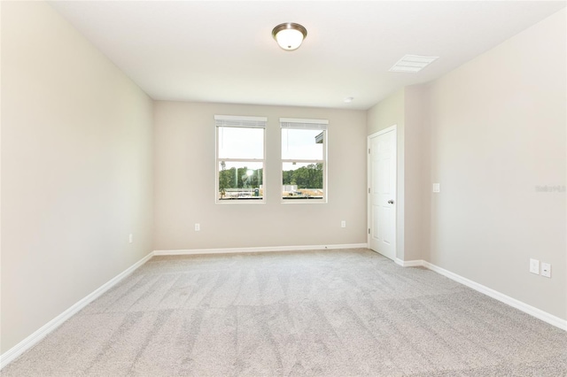 unfurnished room featuring light carpet, visible vents, and baseboards