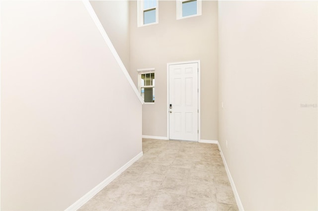 interior space featuring a towering ceiling and baseboards