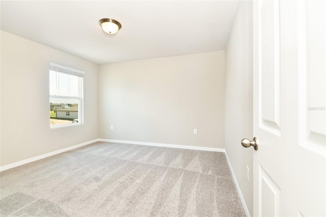 carpeted spare room with baseboards