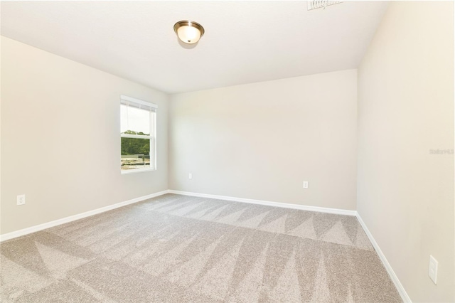 spare room featuring carpet floors and baseboards