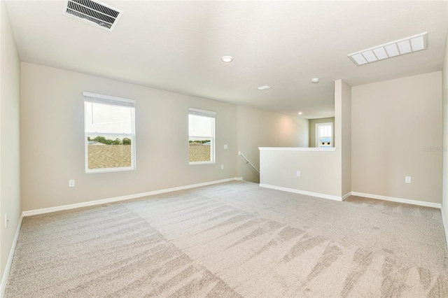 carpeted empty room featuring visible vents and baseboards