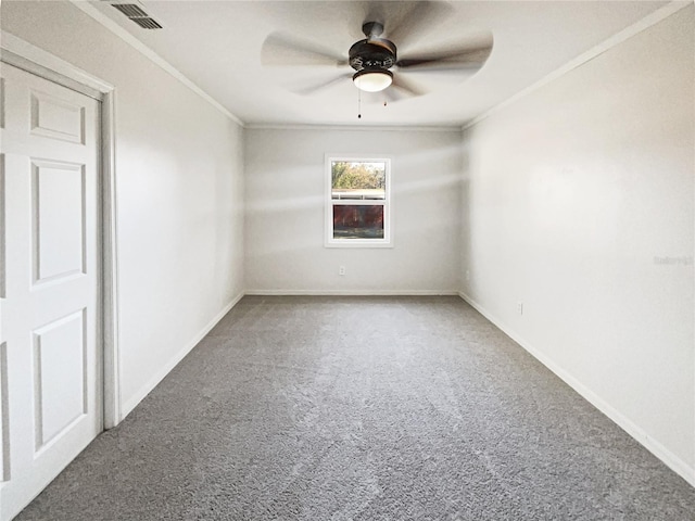 empty room featuring ornamental molding, carpet flooring, visible vents, and baseboards